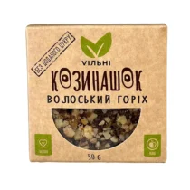 Vegan raw snack packaging with a green leaf logo and a window showing mixed nuts and seeds (50 g).