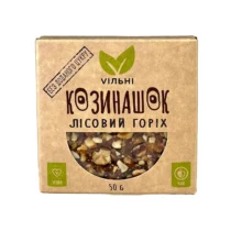 Brown kraft packaging with a rounded window revealing a mixed-nut snack; vegan, raw, 50 g.