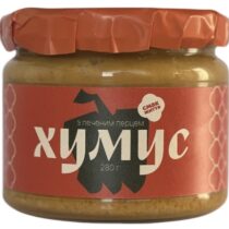 Glass jar of hummus with a red label and orange-sealed lid, Cyrillic text reads 'хумус'.
