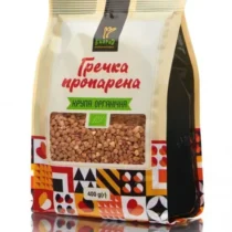Bag of parboiled buckwheat groats in a beige package with a transparent window showing groats, green organic banner, and colorful geometric bottom patterns.