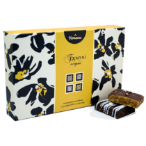 Decorative gift box labeled 'brownie assortment' with two chocolate brownies drizzled with icing beside it in front.